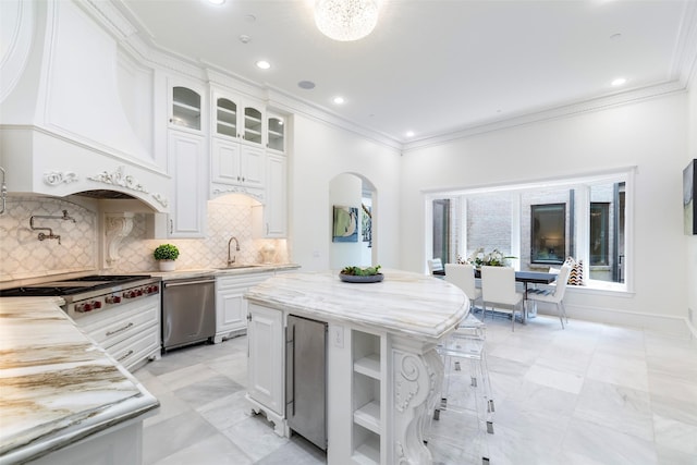 kitchen featuring stainless steel appliances, white cabinets, a center island, tasteful backsplash, and custom exhaust hood