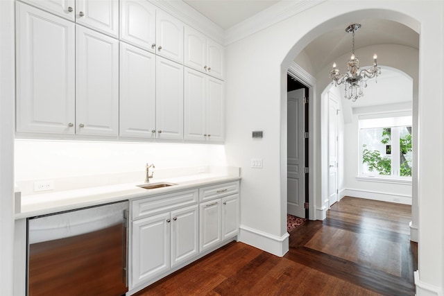 bar with white cabinets, refrigerator, hanging light fixtures, and sink