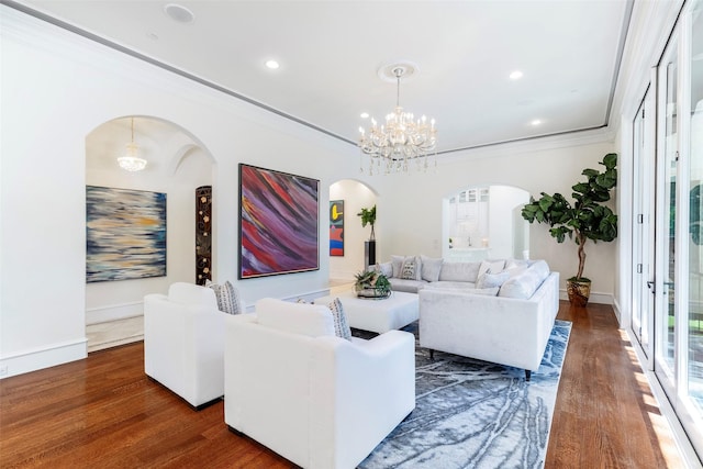 living room with dark hardwood / wood-style floors, crown molding, and a chandelier