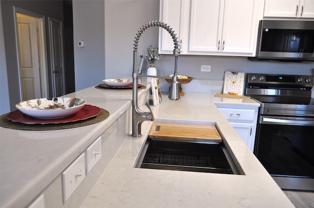 kitchen with stainless steel appliances and white cabinets