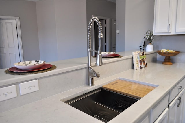 kitchen featuring white cabinetry and sink