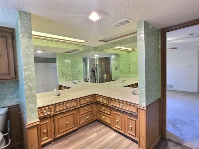 bathroom featuring a textured ceiling, wood-type flooring, and vanity