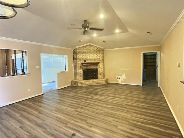 unfurnished living room with dark hardwood / wood-style floors, lofted ceiling, a brick fireplace, ornamental molding, and ceiling fan