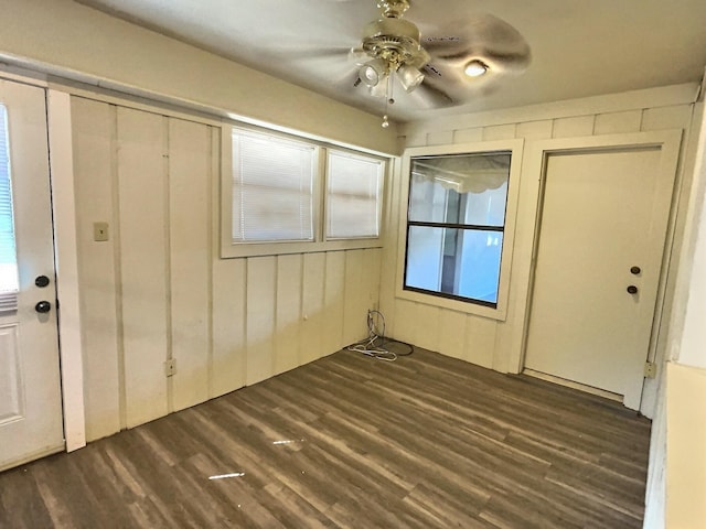 foyer featuring wood walls, ceiling fan, and dark hardwood / wood-style flooring