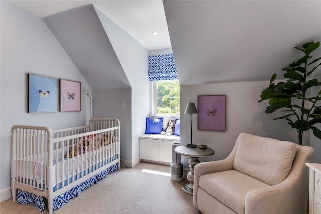 bedroom with light colored carpet, lofted ceiling, and a nursery area