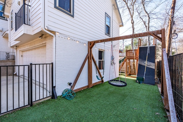 view of side of home featuring a lawn, a playground, and a garage