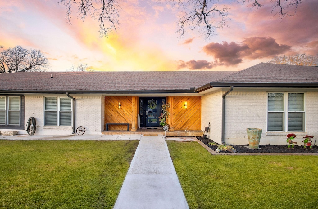 single story home featuring a lawn