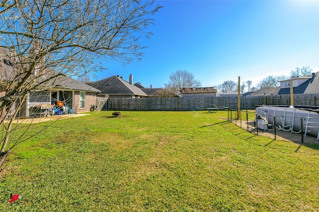 view of yard featuring a covered pool, a patio, and a fenced backyard