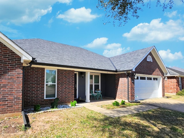 single story home with driveway, roof with shingles, an attached garage, a front lawn, and brick siding