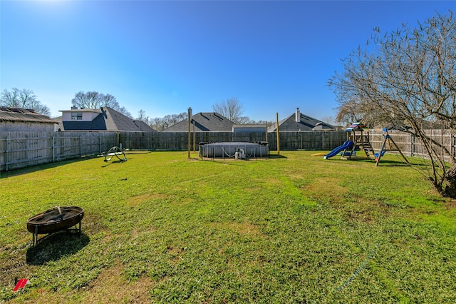 view of yard with an outdoor fire pit and a playground