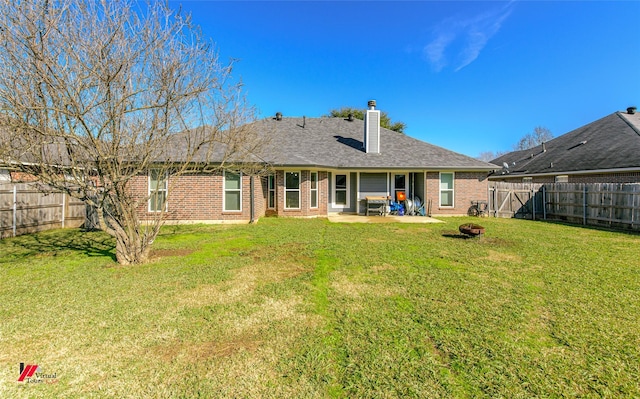 rear view of house with a patio and a yard