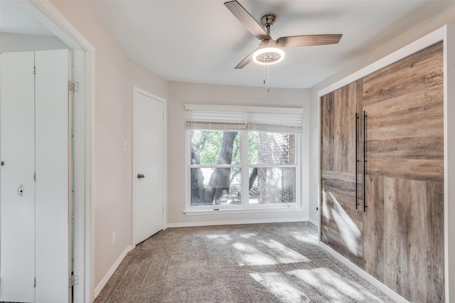 unfurnished room featuring ceiling fan and carpet