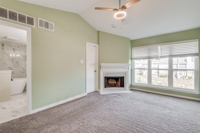 unfurnished living room featuring lofted ceiling, ceiling fan, and light colored carpet