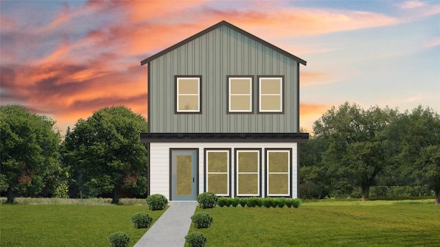 back house at dusk with a lawn