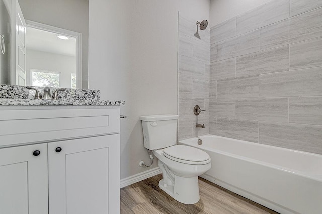 full bathroom with toilet, tiled shower / bath, wood-type flooring, and vanity