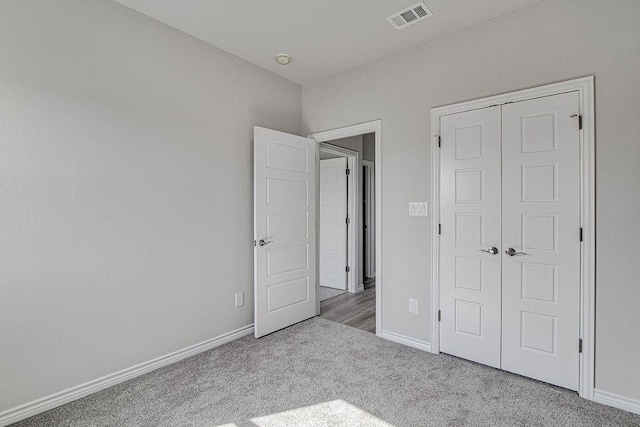 unfurnished bedroom featuring a closet and light colored carpet