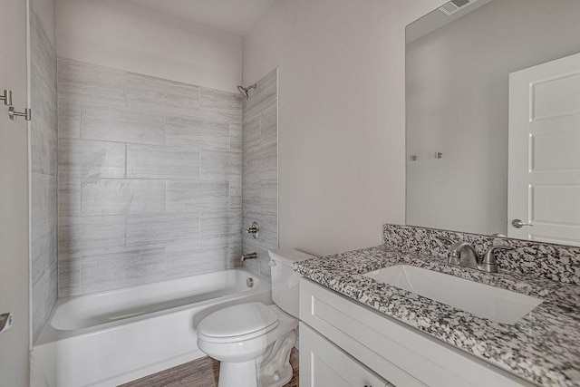 full bathroom with toilet, vanity, hardwood / wood-style floors, and tiled shower / bath