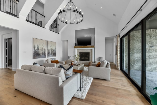 living room featuring a towering ceiling, plenty of natural light, and light hardwood / wood-style flooring