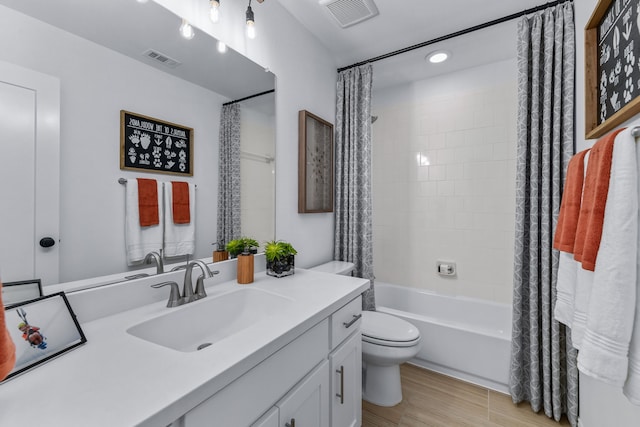 full bathroom featuring toilet, vanity, hardwood / wood-style flooring, and shower / tub combo with curtain