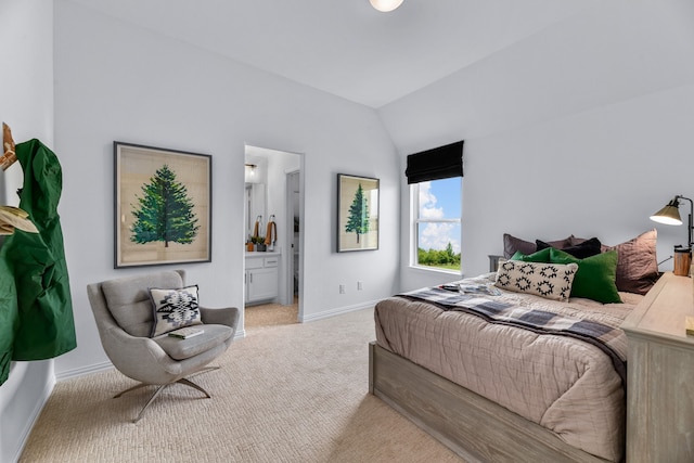 carpeted bedroom with ensuite bath and vaulted ceiling