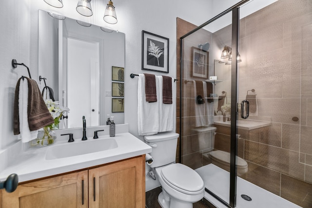 bathroom featuring walk in shower, vanity, and toilet