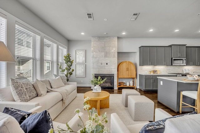 living room featuring a tiled fireplace and light hardwood / wood-style flooring