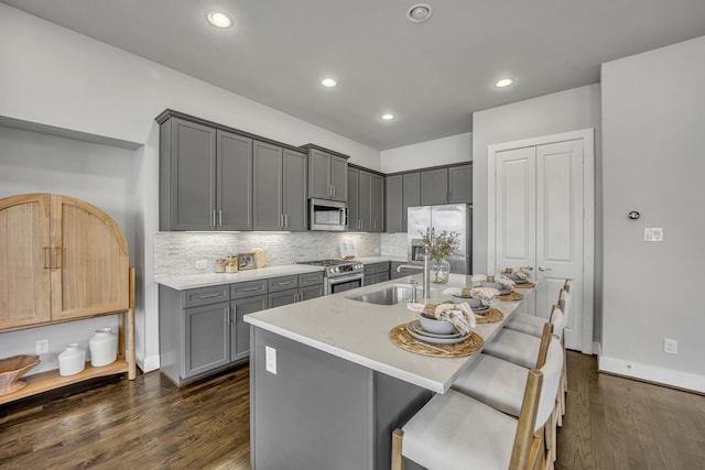 kitchen featuring gray cabinetry, stainless steel appliances, sink, and dark wood-type flooring