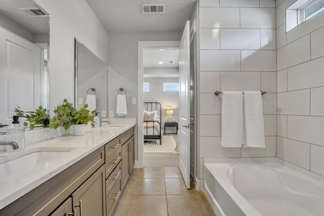 bathroom featuring tile patterned flooring, a tub, and vanity