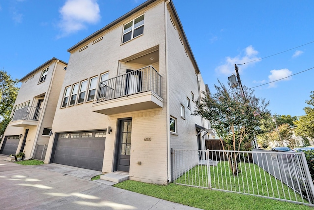 view of front of house featuring a balcony, a front lawn, and a garage