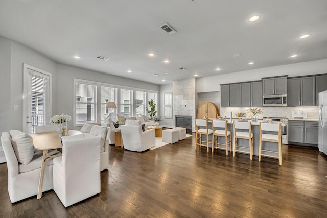 dining area with a tiled fireplace and dark hardwood / wood-style flooring