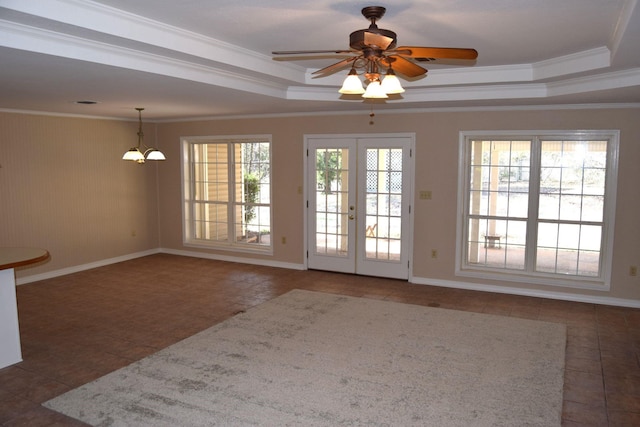 doorway with ceiling fan with notable chandelier, a raised ceiling, crown molding, and a wealth of natural light