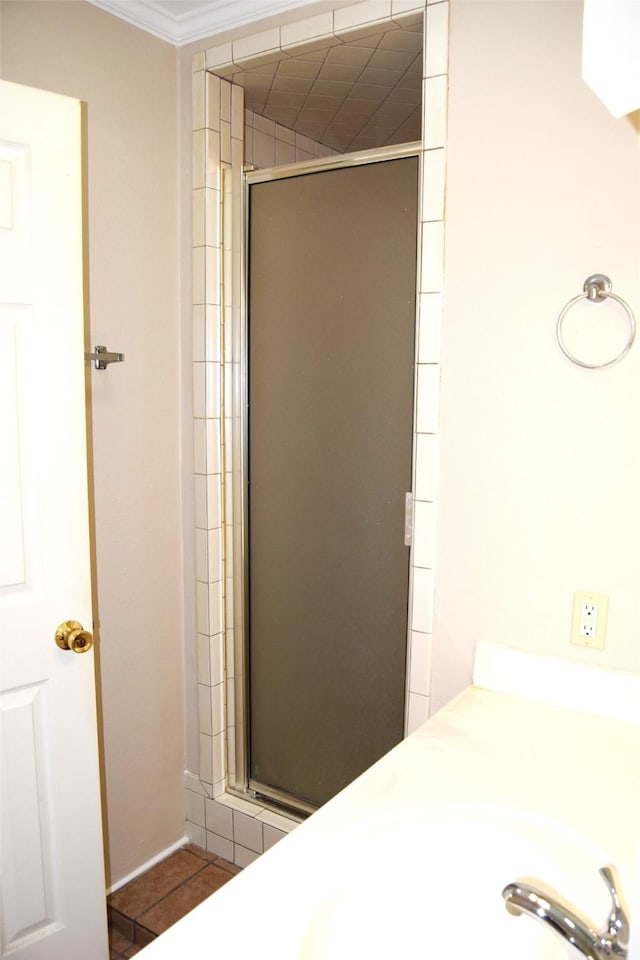 bathroom with ornamental molding, tile patterned floors, an enclosed shower, and sink