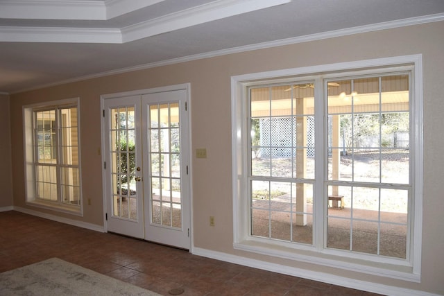 doorway with french doors, dark tile patterned flooring, and ornamental molding