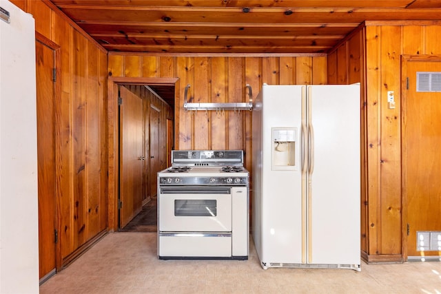 kitchen featuring white appliances and wood walls