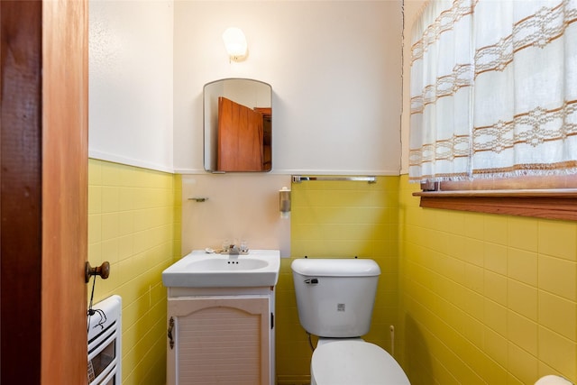 bathroom with tile walls, vanity, and toilet