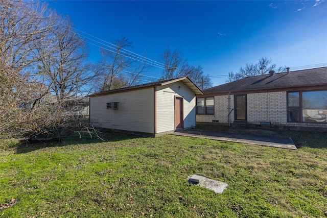 view of home's exterior featuring a patio area, a yard, and an outdoor structure