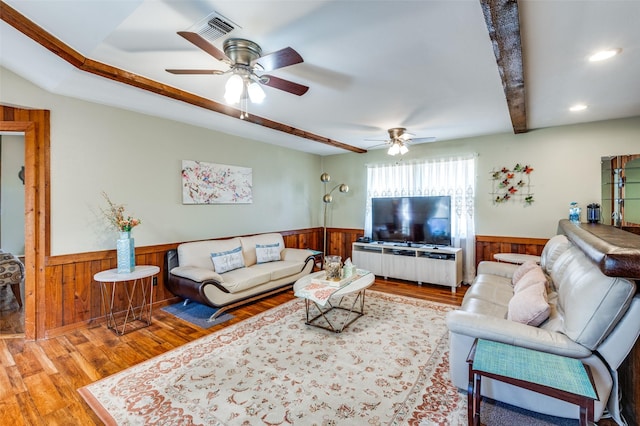 living room featuring ceiling fan, hardwood / wood-style flooring, and beamed ceiling