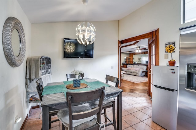 dining area featuring ceiling fan with notable chandelier and light tile patterned floors