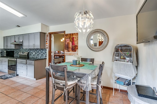 dining area featuring a notable chandelier and light tile patterned floors