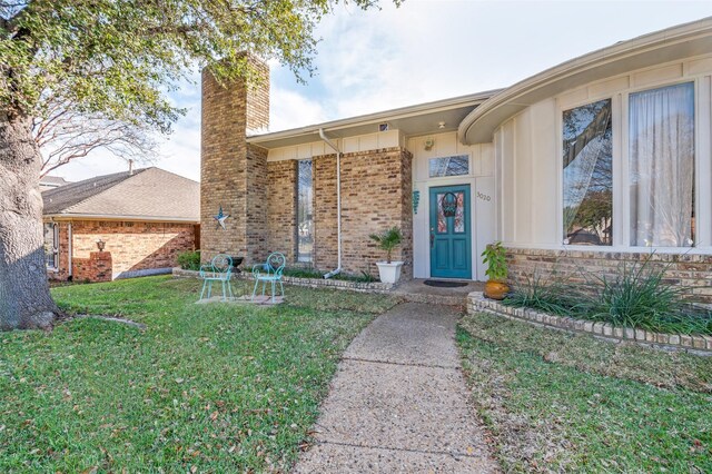 view of exterior entry featuring a yard