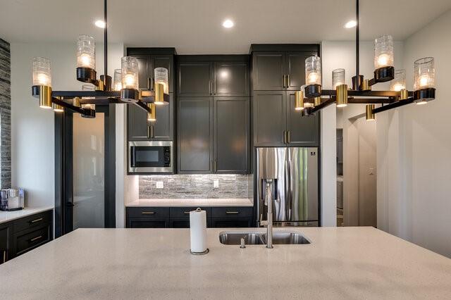 kitchen featuring sink, stainless steel appliances, tasteful backsplash, and pendant lighting