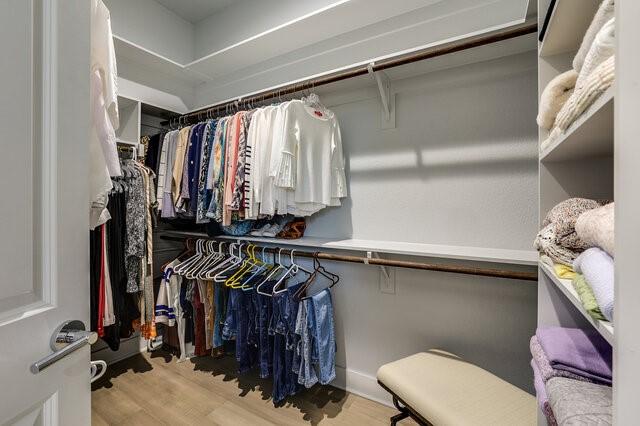 spacious closet with light hardwood / wood-style flooring