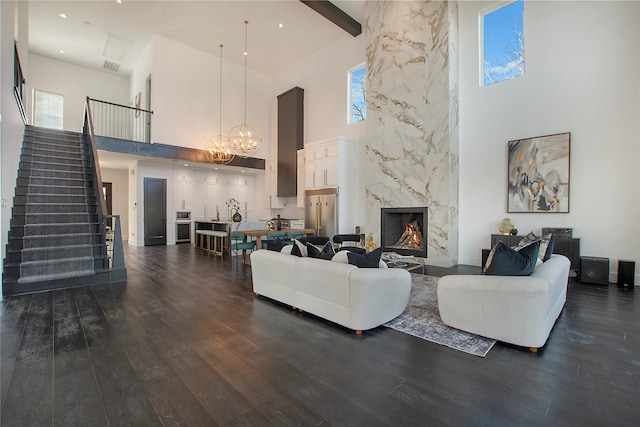 living room with a towering ceiling, a premium fireplace, and dark hardwood / wood-style flooring