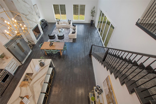 living room with dark wood-type flooring, an inviting chandelier, and a fireplace