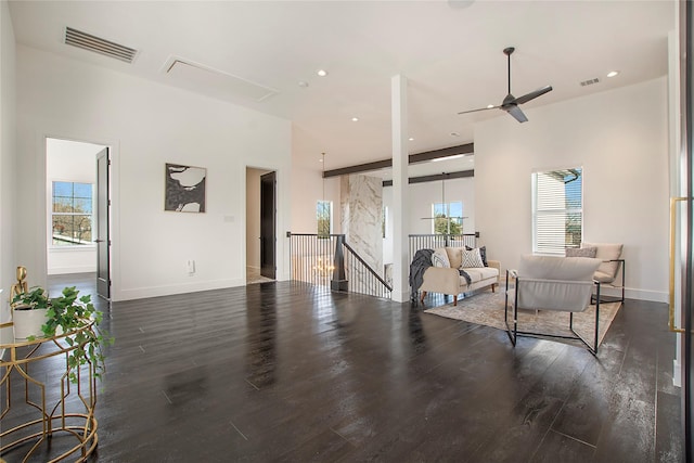 living room with a healthy amount of sunlight, dark wood-type flooring, and ceiling fan