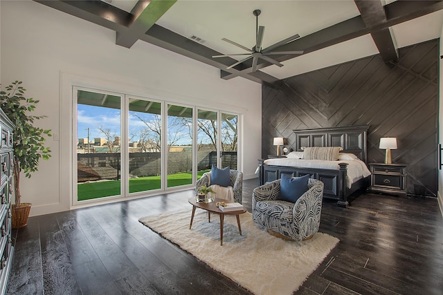 bedroom with access to exterior, wood walls, beam ceiling, and dark wood-type flooring