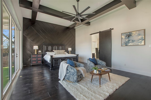 bedroom with dark hardwood / wood-style flooring, a barn door, and beam ceiling