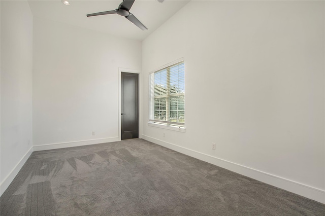 unfurnished room with ceiling fan, high vaulted ceiling, and dark colored carpet