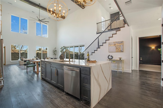 kitchen featuring sink, decorative light fixtures, dishwasher, light stone counters, and dark wood-type flooring