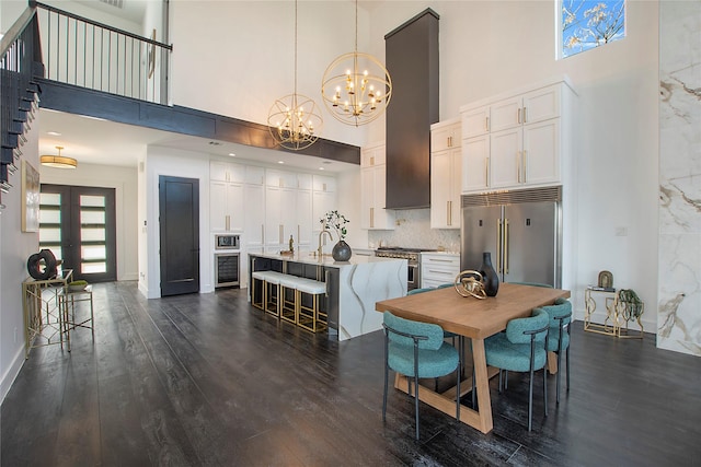 dining space with a high ceiling, french doors, dark hardwood / wood-style flooring, and wine cooler